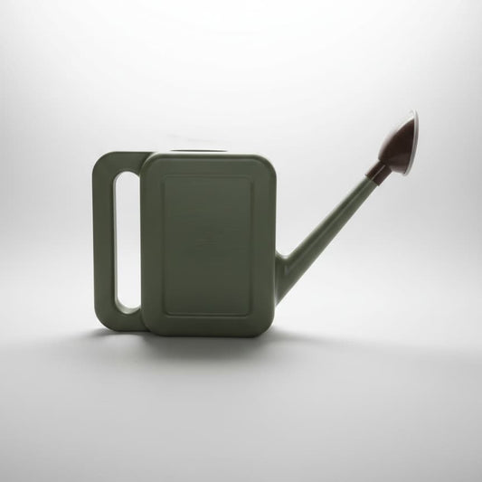 Vue de profil d'un arrosoir pour plantes d'intérieur de 1 litre, couleur vert sauge mat, avec un long bec fin et une pomme d'arrosage marron sur un fond blanc épuré.