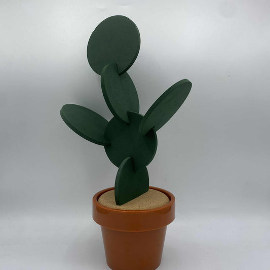 Une décoration de cactus raquette en bois vert foncé dans un pot en plastique marron.