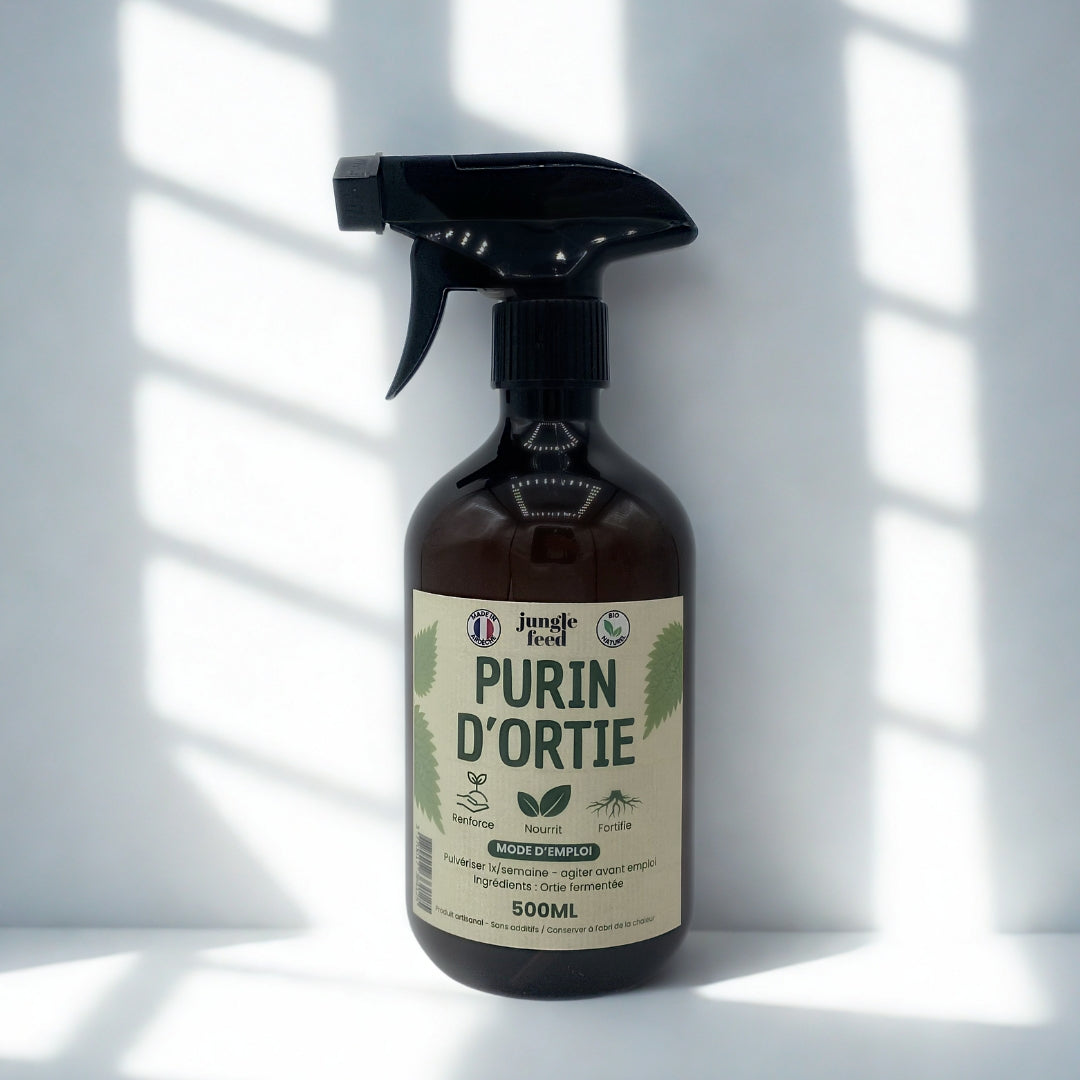 Une bouteille du produit "Jungle Feed Purin d'Ortie", posée sur un fond blanc avec des ombres de persiennes en arrière-plan. La bouteille est foncée et opaque et le nom du produit est bien visible sur l'étiquette.