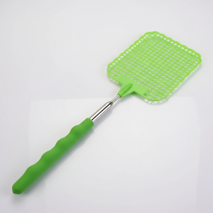 Photographie de produit d'une tapette à mouches verte avec un manche télescopique. L'objet est posé sur une surface blanche réfléchissante devant un fond gris clair uni. L'éclairage est doux et uniforme, typique d'une photo de studio.