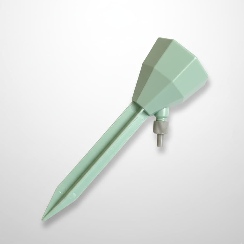 Arroseur automatique goutte-à-goutte vert pastel pour plantes d'intérieur, présenté de profil sur un fond blanc et gris épuré avec éclairage professionnel.