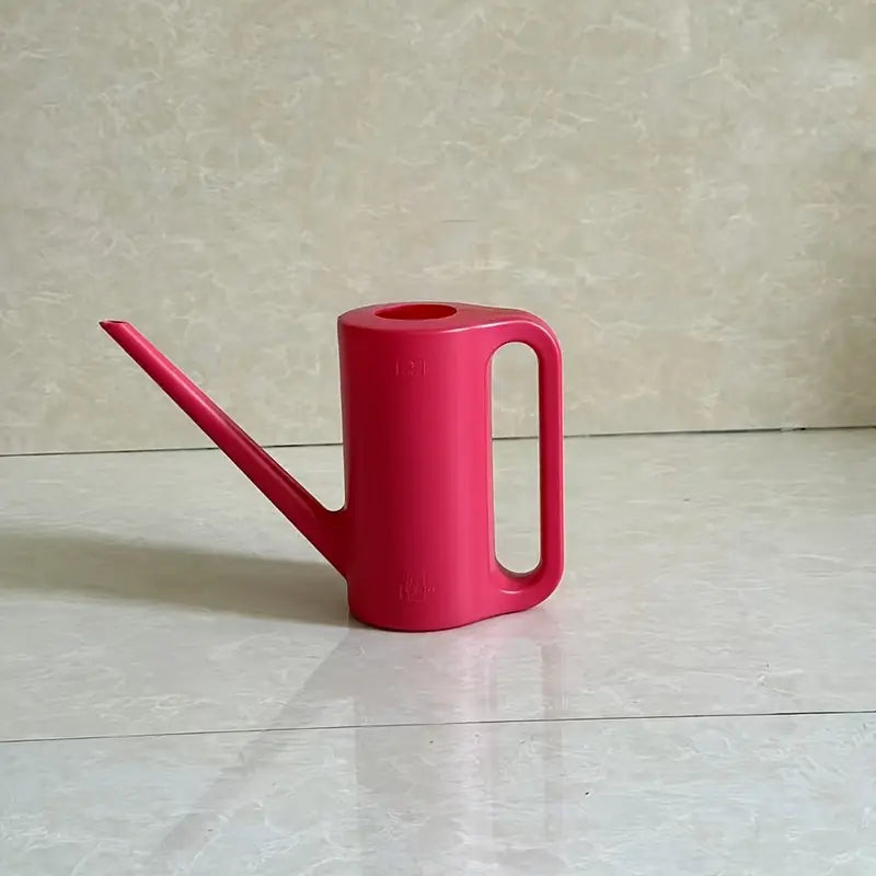 Un arrosoir minimaliste en plastique rouge vif de 1.2 litres, posé sur un sol carrelé.