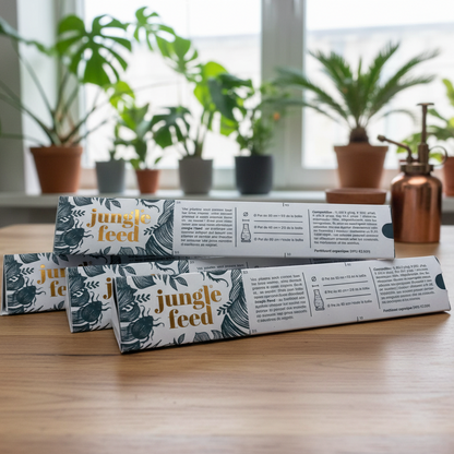 4 Boîtes de bâtonnets d'engrais "Jungle Feed" avec des instructions d'utilisation pour les plantes en pot, sur une table en bois.