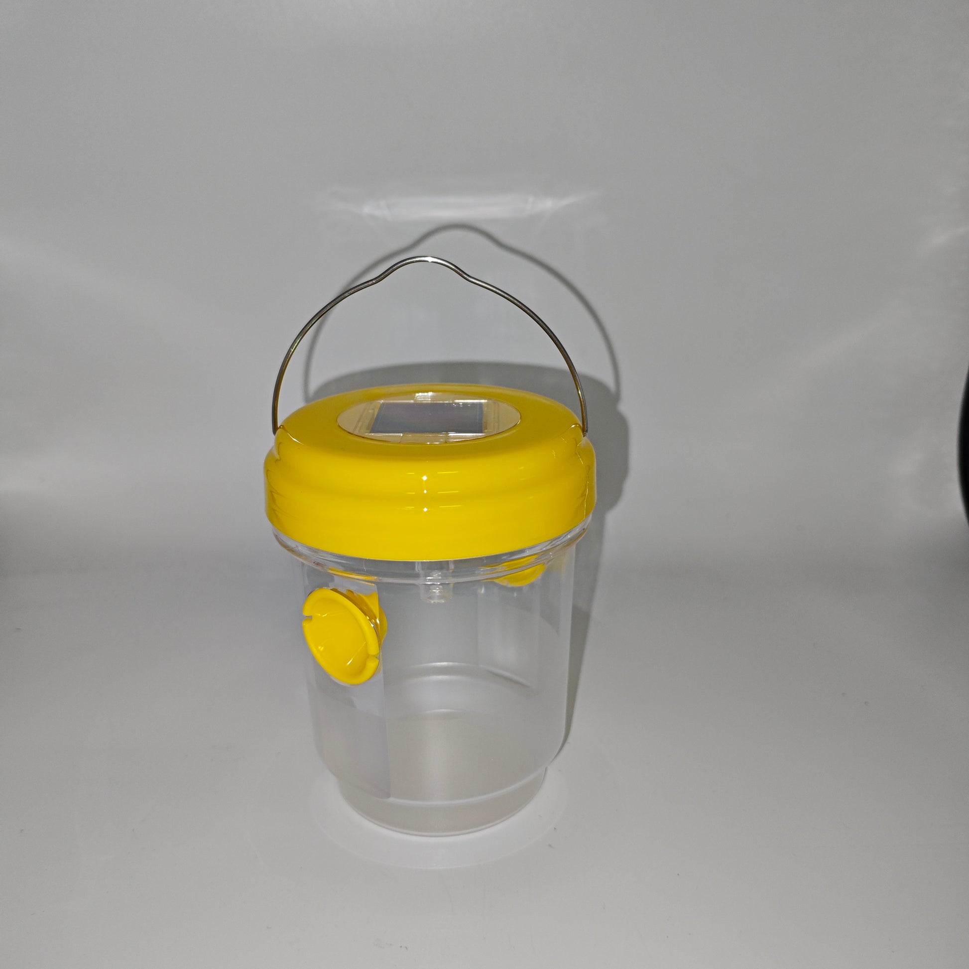 Un piège à guêpes ou à insectes cylindrique avec un couvercle jaune et un panneau solaire intégré, conçu pour une utilisation en extérieur.