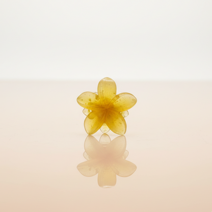 Mini pince à cheveux jaune en résine, représentant une fleur aux pétales délicats. Idéale pour une demi-attache ou pour retenir une mèche de cheveux.