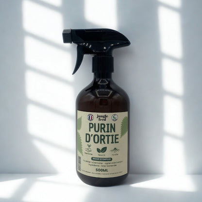Une bouteille du produit "Jungle Feed Purin d'Ortie", posée sur un fond blanc avec des ombres de persiennes en arrière-plan. La bouteille est foncée et opaque et le nom du produit est bien visible sur l'étiquette.