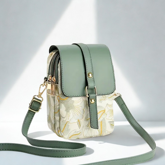 Un petit sac à bandoulière pour téléphone, de couleur vert sauge et crème, avec un motif floral brodé et des détails dorés.