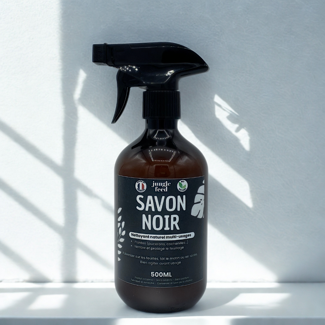 Bouteille de Savon Noir prêt à l'emploi de 500 ml, un produit de soin des plantes et insecticide naturel pour lutter contre les pucerons. Le flacon est mis en scène près de plantes saines