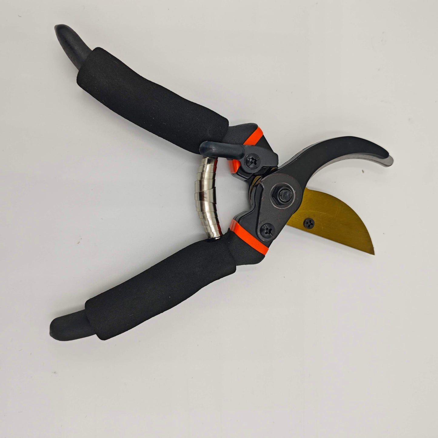 Un sécateur de jardinage professionnel avec des poignées noires, un ressort hélicoïdal, et une lame de couleur dorée.